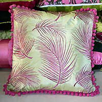 Cushion cover trimmed with pom poms.