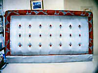 Headboard standard shape with edging and buttons.