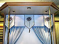 Padded pelmet in suede with blue and white silk flags.